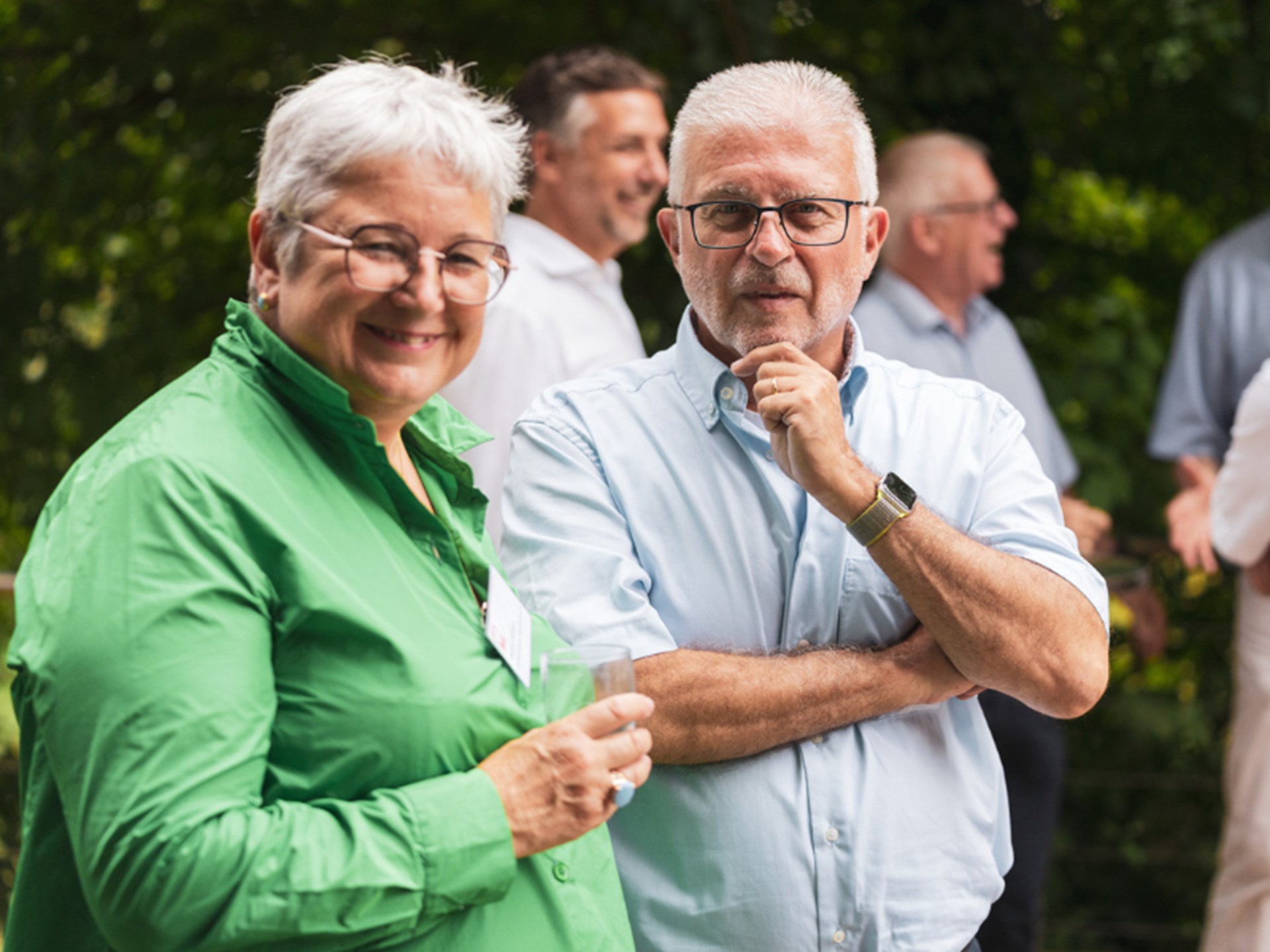 Eine Frau mit kurzen grauen Haaren und Brille sowie ein Mann mit ebenfalls kurzen grauen Haaren und Brille lächeln in die Kamera.